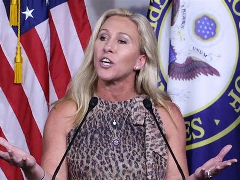 A woman in a leopard-print top speaking at a podium with U.S. House of Representatives signage—capturing a public moment possibly linked to statements or press coverage on Marjorie Taylor Greene resignation
